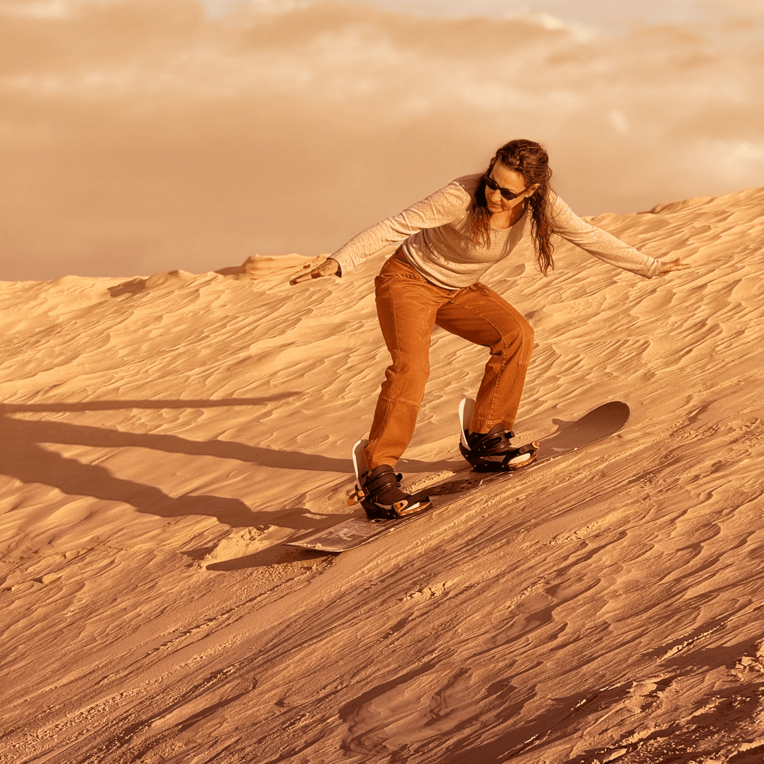 Sandboarder dévalant une dune